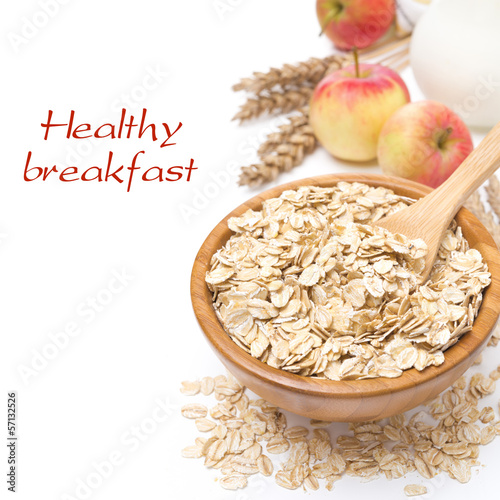 Photo: Oat flakes in a bowl and apples in the background, isolated Oat flakes in a bowl and apples in the background, isolated