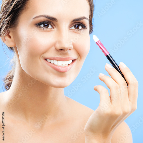 Photo: Woman with cosmetics brush, on blue Woman with cosmetics brush, on blue