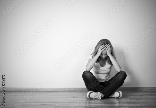 Photo: girl sits in a depression on the floor near the wall girl sits in a depression on the floor near the wall