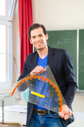 Photo: Teacher with triangle in front of a school class Teacher with triangle in front of a school class