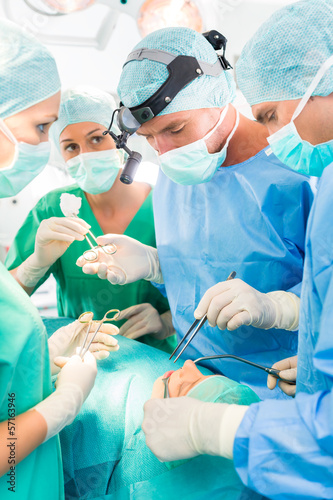 Photo: Surgeons operating patient in operation theater Surgeons operating patient in operation theater