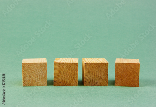 Photo: wooden geometric cube on a green background wooden geometric cube on a green background