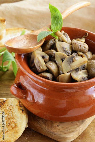 Photo: mushroom ragout of champignons and basil on a wooden table mushroom ragout of champignons and basil on a wooden table