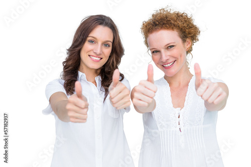 Photo: Two beautiful casual models posing with thumbs up Two beautiful casual models posing with thumbs up