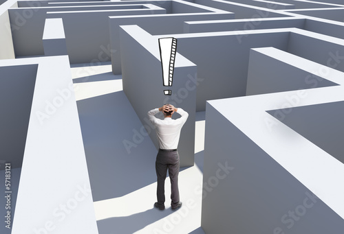 Photo: Rear view of desperate businessman standing in maze Rear view of desperate businessman standing in maze