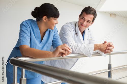 Photo: Doctor and nurse smiling and leaning against rail Doctor and nurse smiling and leaning against rail