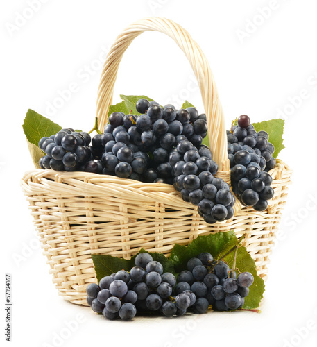 Photo: Wicker basket full of fresh red grapes isolated on white Wicker basket full of fresh red grapes isolated on white