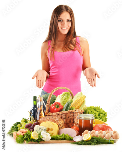 Photo: Young woman with assorted grocery products isolated on white Young woman with assorted grocery products isolated on white