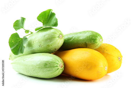 Photo: Raw yellow and green zucchini with leaves, isolated on white Raw yellow and green zucchini with leaves, isolated on white