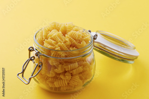 Photo: Raw radiatori pasta on a glass jar Raw radiatori pasta on a glass jar