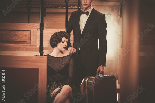 Photo: Beautiful vintage style couple inside retro train coach Beautiful vintage style couple inside retro train coach