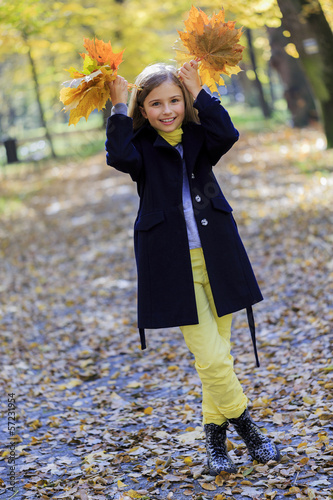 Photo: Autumn fun - lovely girl has a fun in autumn park Autumn fun - lovely girl has a fun in autumn park