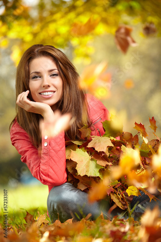 Photo: Young woman with autumn leaves in hand and fall yellow maple gar Young woman with autumn leaves in hand and fall yellow maple gar