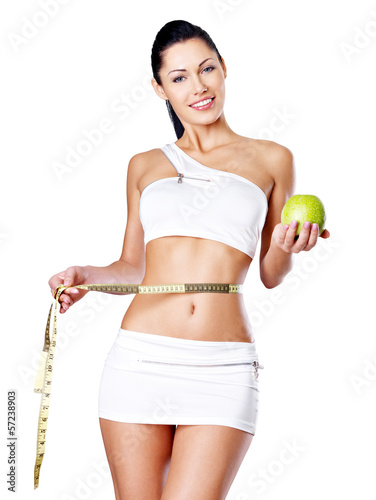 Photo: Slimming woman with a measuring tape and apple Slimming woman with a measuring tape and apple