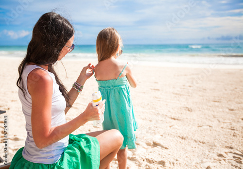 Photo: Mother protects her baby from the sun with suncream Mother protects her baby from the sun with suncream