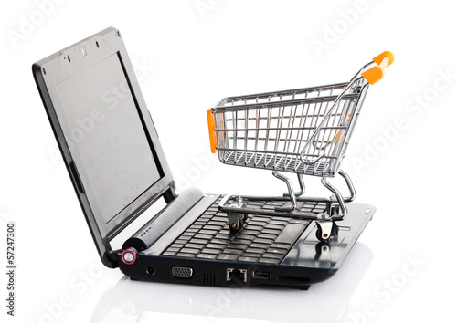 Photo: Online shopping. Shopping cart with notebook on the white. shopp Online shopping. Shopping cart with notebook on the white. shopp