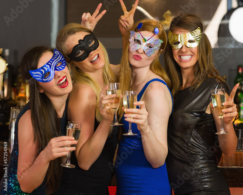 Photo: Attractive women wearing masks holding champagne Attractive women wearing masks holding champagne