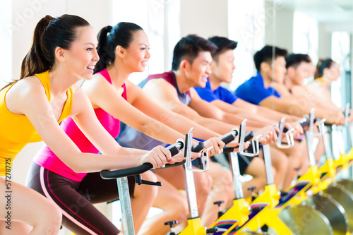 Photo: Asian people in spinning bike training at fitness gym Asian people in spinning bike training at fitness gym