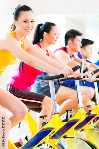 Photo: Asian people in spinning bike training at fitness gym Asian people in spinning bike training at fitness gym