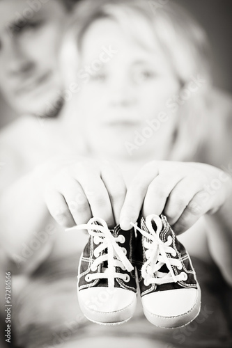 Photo: pregnant woman and husband with a child's shoe pregnant woman and husband with a child's shoe