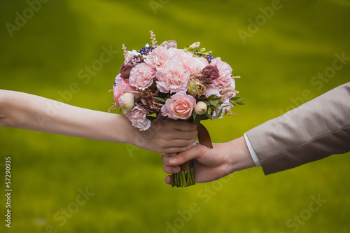 Photo: wedding bouquet in the newlywed's hands wedding bouquet in the newlywed's hands