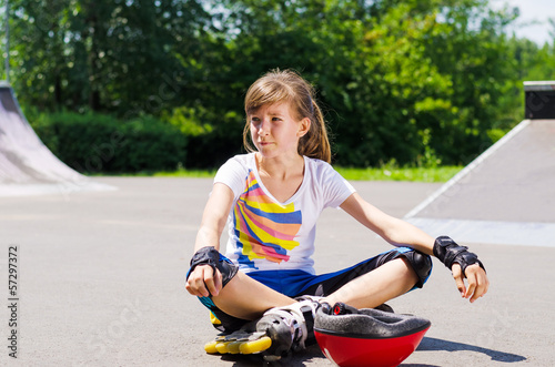 Photo: Young girl relaxing with her skating gear Young girl relaxing with her skating gear