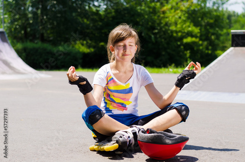 Photo: Pretty young teenager sitting meditating Pretty young teenager sitting meditating