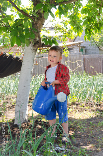 Photo: Cute little boy helping in the vegetable garden Cute little boy helping in the vegetable garden