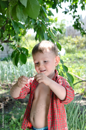 Photo: Smiling little boy holding a wriggling worm Smiling little boy holding a wriggling worm