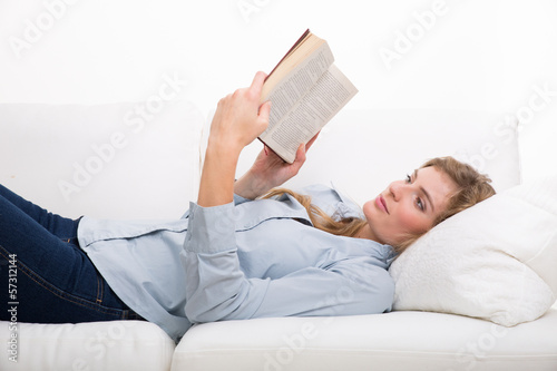 Photo: frau liest buch auf der couch frau liest buch auf der couch