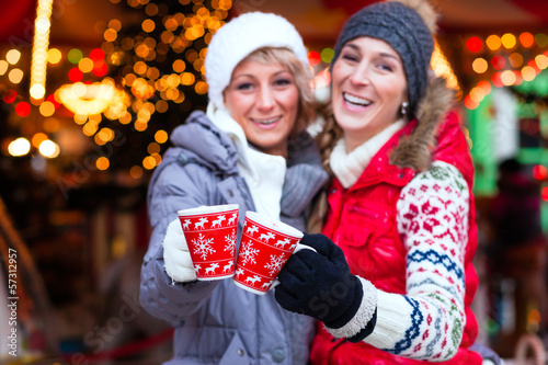 Photo: Freunde trinken Glühwein auf Weihnachtsmarkt zur Adventszeit Freunde trinken Glühwein auf Weihnachtsmarkt zur Adventszeit