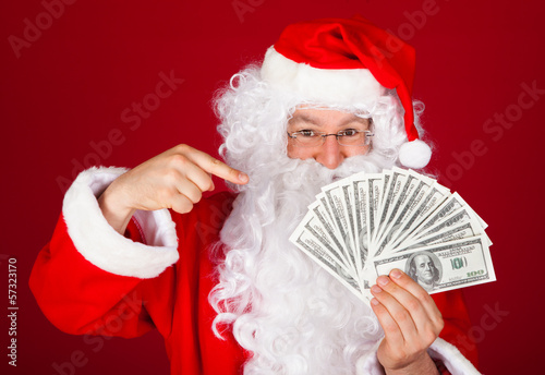 Photo: Happy santa holding dollars Happy santa holding dollars