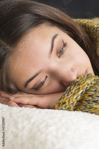 Photo: Pensive young woman lying on couch Pensive young woman lying on couch