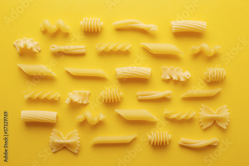 Photo: Different types of pasta on yellow background Different types of pasta on yellow background