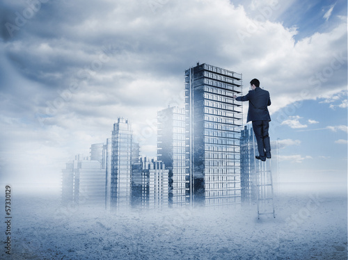 Photo: Rear view of businessman touching holographic city Rear view of businessman touching holographic city