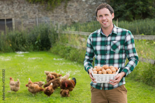 Photo: Proud young man holding a basket filled with eggs Proud young man holding a basket filled with eggs