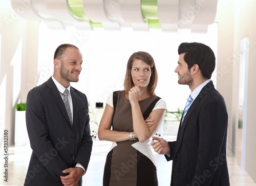 Photo: Business people talking in office corridor Business people talking in office corridor