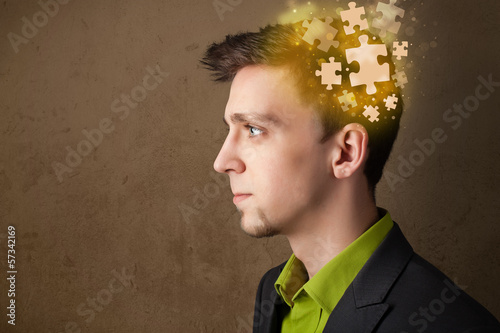 Photo: Young person thinking with glowing puzzle mind Young person thinking with glowing puzzle mind