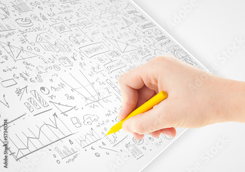 Photo: Human hand sketching ideas on a white paper Human hand sketching ideas on a white paper