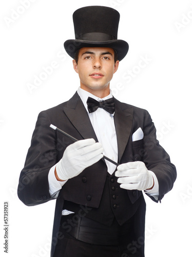 Photo: magician in top hat with magic wand showing trick magician in top hat with magic wand showing trick
