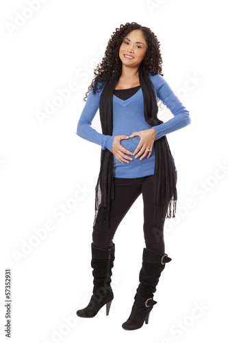 Photo: Pregnant woman in winter clothing makes a heart shape over her b Pregnant woman in winter clothing makes a heart shape over her b