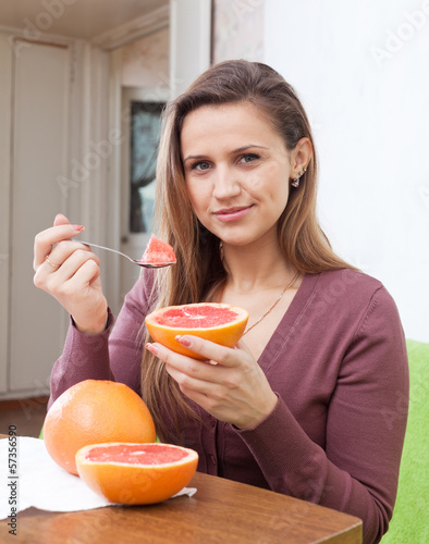 Photo: long-haired girl eats grapefruit long-haired girl eats grapefruit