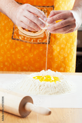 Photo: chef cracking egg into flour chef cracking egg into flour