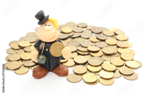 Photo: Chimney sweep on a pile of coins. Isolated on white Chimney sweep on a pile of coins. Isolated on white