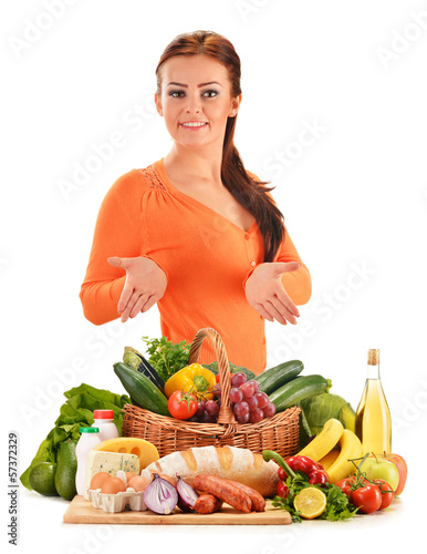 Photo: Young woman with assorted grocery products isolated on white Young woman with assorted grocery products isolated on white