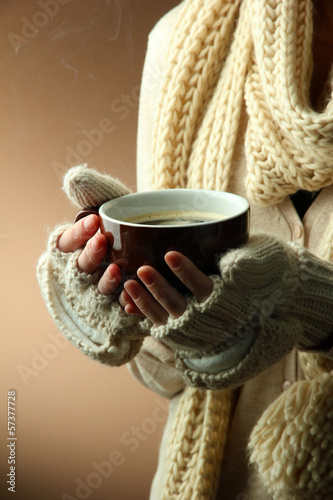 Photo: Female hands with hot drink, on color background Female hands with hot drink, on color background