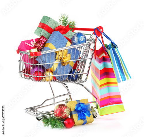 Photo: Christmas gifts in shopping trolley, isolated on white Christmas gifts in shopping trolley, isolated on white