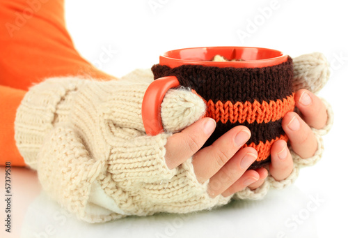Photo: Cup with knitted thing on it in female hands isolated on white Cup with knitted thing on it in female hands isolated on white