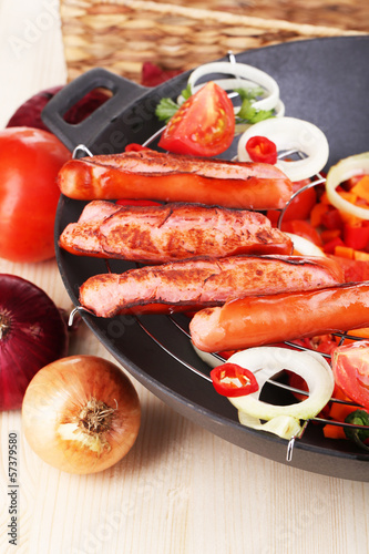 Photo: Delicious sausages with vegetables in wok Delicious sausages with vegetables in wok