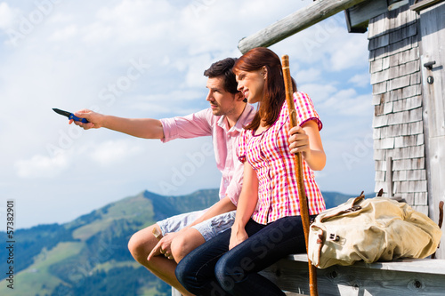 Photo: Alpen - Mann und Frau vor Almhütte in Bergen Alpen - Mann und Frau vor Almhütte in Bergen